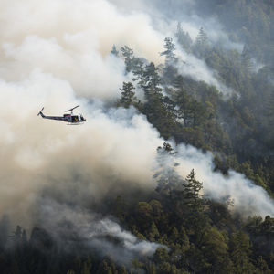 Helicopter flying above a forest fire
