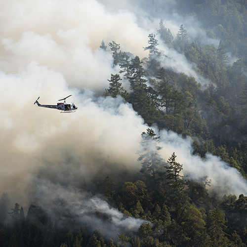 Helicopter flying over a forest fire