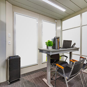 office with standing desk, chairs and an air purifier